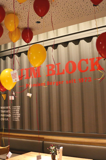 Rotes und gelbes Luftballon-Dekor schwebt unter der Decke im neuen Jim Block Restaurant Rostock – feierliche Eröffnung im modernen, urbanen Stil.