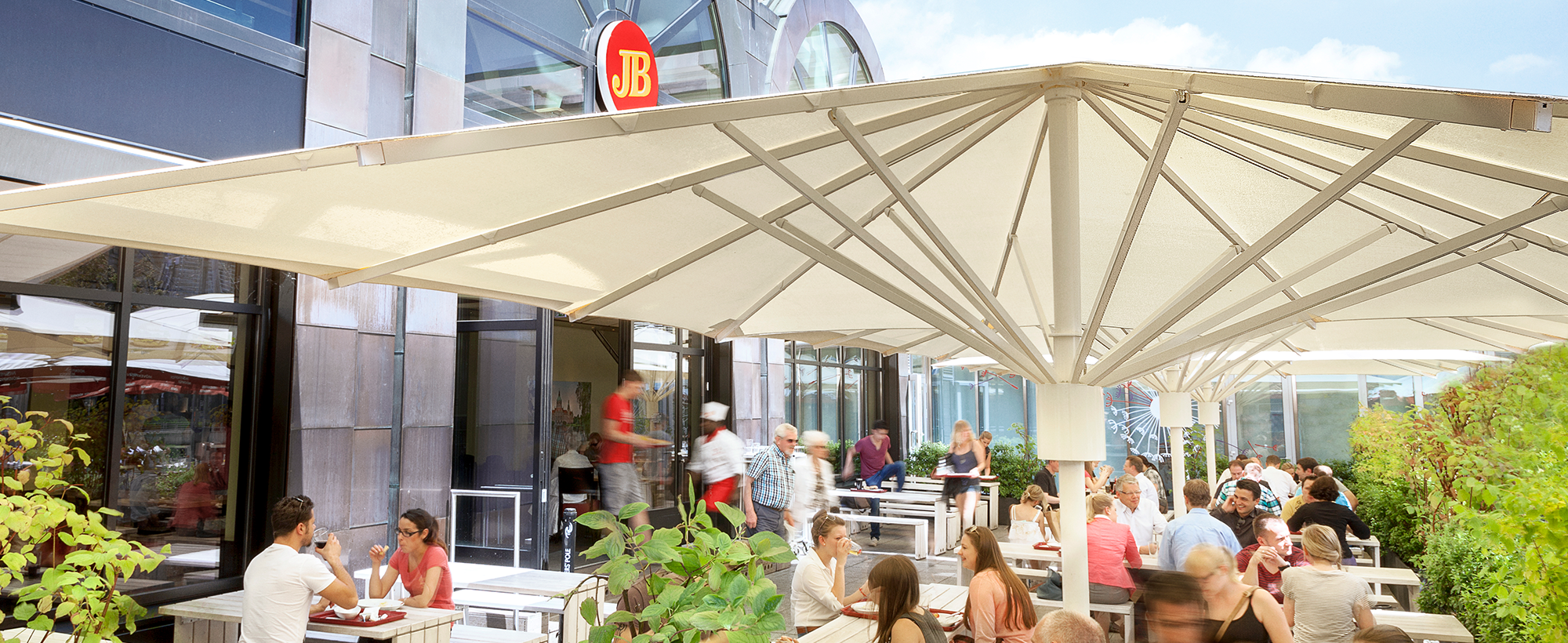 Außenterrasse des Jim Block Restaurants in Hannover bei sonnigem Wetter mit vielen Gästen.