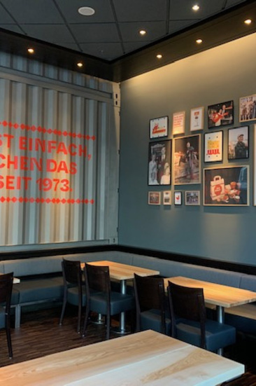 Innenansicht eines Jim Block Restaurants in Hamburg mit Wandgrafiken und Sitzplätzen.